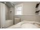 Bright bathroom featuring subway tile, a window and a shower with a bathtub at 3840 N Washington Blvd, Indianapolis, IN 46205