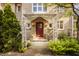 Inviting front entrance with a decorative canopy, red door, brick facade, and lush ferns at 3840 N Washington Blvd, Indianapolis, IN 46205