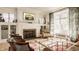 Bright living room features hardwood floors, a decorative fireplace, and large windows at 3840 N Washington Blvd, Indianapolis, IN 46205