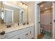 Bathroom featuring dual sinks, white cabinets, and a doorway to the toilet and shower at 4061 Secretariat Ln, Bargersville, IN 46106