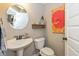 Small half-bathroom with a pedestal sink, toilet, decorative shelf, and colorful artwork at 4061 Secretariat Ln, Bargersville, IN 46106