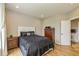 Bedroom with a dark bedspread, wooden furniture, and neutral-toned walls and flooring at 4061 Secretariat Ln, Bargersville, IN 46106
