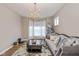 Comfortable living room with a stylish couch, elegant chandelier, and large windows at 4061 Secretariat Ln, Bargersville, IN 46106