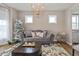 Cozy living room with stylish sofa, decorative tree, and elegant chandelier at 4061 Secretariat Ln, Bargersville, IN 46106
