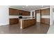 A view of the kitchen featuring wood cabinets, stone countertops, and an island with white pillars on a wooden floor at 4125 Sugar Pine Ln, Zionsville, IN 46077