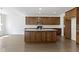 A view of the kitchen showcasing wood cabinets, granite countertops, and an island with a sink, all on a wooden floor at 4125 Sugar Pine Ln, Zionsville, IN 46077