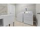Functional laundry room with utility sink, storage shelves, and included washer and dryer at 4181 Gordman Dr, Whitestown, IN 46075