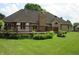 Wood deck in backyard with brick home, chimney, lush lawn and mature landscaping at 4288 Silver Hill Dr, Greenwood, IN 46142