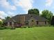 Spacious backyard with a brick home, chimney, lush lawn and large wood deck at 4288 Silver Hill Dr, Greenwood, IN 46142
