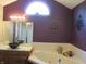 A bathroom with a tub, vanity, vessel sink, light fixture, and decorative elements on a plum wall at 4288 Silver Hill Dr, Greenwood, IN 46142