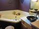 A bathroom with a corner tub, vanity, vessel sink, and white countertop at 4288 Silver Hill Dr, Greenwood, IN 46142
