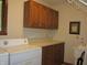 Functional laundry room with ample storage cabinets, a utility sink, and laundry machines at 4288 Silver Hill Dr, Greenwood, IN 46142