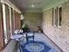 Relaxing sunroom showcasing brick walls, wicker furniture, wood floors, and natural light from large windows at 4288 Silver Hill Dr, Greenwood, IN 46142