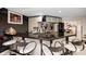 Basement bar area with black countertop, four stools and white cabinets with mirrored backsplash at 434 Sheffield Ct, Carmel, IN 46032