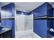 Modern bathroom with a shower-tub combination and blue accent walls with black and white stripes at 434 Sheffield Ct, Carmel, IN 46032