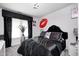 Chic bedroom featuring a plush bed with a black comforter, unique chandelier, and decorative red lips decal at 434 Sheffield Ct, Carmel, IN 46032