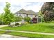 Well-manicured front lawn with mature trees frames a spacious home with inviting curb appeal at 434 Sheffield Ct, Carmel, IN 46032