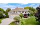 Aerial view of a well-manicured property showcasing lush landscaping and a charming two-story home with a three-car garage at 434 Sheffield Ct, Carmel, IN 46032