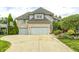 Inviting two-story brick home featuring a spacious driveway and a basketball hoop for outdoor recreation at 434 Sheffield Ct, Carmel, IN 46032