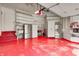 Well-organized garage with shelving, dual refrigerators, and a glossy red epoxy floor at 434 Sheffield Ct, Carmel, IN 46032