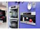 Stainless steel appliances built into violet wall, including double ovens and integrated Miele coffee maker at 434 Sheffield Ct, Carmel, IN 46032