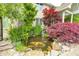 Beautiful koi pond with colorful fish, lush greenery, and a charming waterfall feature at 434 Sheffield Ct, Carmel, IN 46032