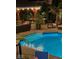 Inviting pool with illuminated steps, outdoor seating area and covered pergola at night at 434 Sheffield Ct, Carmel, IN 46032