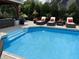 Backyard pool featuring lounge chairs and a covered patio area with landscaping at 434 Sheffield Ct, Carmel, IN 46032