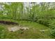 A sprawling backyard featuring tiered landscaping, mature trees, steps, and stone pathways at 470 Mill Farm Rd, Noblesville, IN 46062
