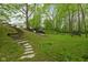 Expansive backyard with stone steps leading to lush greenery and wooded area at 470 Mill Farm Rd, Noblesville, IN 46062