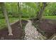 Landscaped backyard with a stone pathway and mulch, surrounded by mature trees and lush greenery at 470 Mill Farm Rd, Noblesville, IN 46062