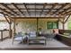 Cozy covered patio with stone accents, seating and ceiling fan at 470 Mill Farm Rd, Noblesville, IN 46062