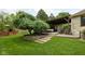 Outdoor patio area with pergola, mature tree and stairs to lush backyard at 470 Mill Farm Rd, Noblesville, IN 46062
