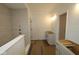 Hallway leading to bathroom with walk-in shower, modern vanity, and neutral toned ceramic tile at 5032 Carmine St, Brownsburg, IN 46112