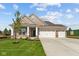 Beautiful brick home with a three-car garage, a well-kept lawn, and a cozy front porch under a blue sky at 5032 Carmine St, Brownsburg, IN 46112