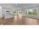 Open-concept living space with hardwood floors, large windows, and a kitchen featuring a central island at 5032 Carmine St, Brownsburg, IN 46112