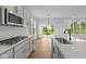 Modern kitchen with stainless steel appliances, gray cabinets, quartz countertops and a view to the backyard at 5032 Carmine St, Brownsburg, IN 46112