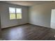 Well-lit bedroom with wood flooring, a large window, and white walls offering a serene and inviting atmosphere at 5203 Cartland Dr, Indianapolis, IN 46239