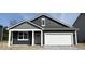 Charming single-story home featuring a white garage door, dark siding, and eye-catching architectural details at 5203 Cartland Dr, Indianapolis, IN 46239