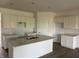 Bright kitchen features white cabinets, an island with quartz countertop, and stainless steel double sink at 5203 Cartland Dr, Indianapolis, IN 46239