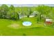 Aerial view of a property with an above-ground pool, surrounded by lush greenery and a barn at 5335 W 550 S, Trafalgar, IN 46181