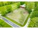 Aerial view of a large property with an empty horse corral next to a red barn and a road at 5335 W 550 S, Trafalgar, IN 46181