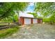 Red barn featuring garage doors, providing practical storage solutions, complemented by a gravel driveway at 5335 W 550 S, Trafalgar, IN 46181