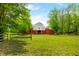 Picturesque view of a red barn on a lush green pasture with trees at 5335 W 550 S, Trafalgar, IN 46181