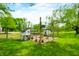 A charming chicken coop with chickens in a spacious, fenced-in area on lush green grass under a bright, sunny sky at 5335 W 550 S, Trafalgar, IN 46181