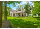 Beautiful two-story farmhouse with a covered porch and lush green lawn at 5335 W 550 S, Trafalgar, IN 46181
