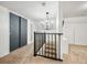 Upstairs hallway with a black rod iron railing and a modern chandelier at 5335 W 550 S, Trafalgar, IN 46181