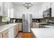 Bright kitchen with stainless steel refrigerator, white cabinetry, and hardwood floors at 5335 W 550 S, Trafalgar, IN 46181