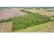 Aerial view shows wooded area with bright green foliage and surrounding farmland at 5758 N 1200 E, Sheridan, IN 46069