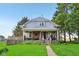 Charming two-story home featuring a covered front porch, steps to the front door, and mature trees on a lush green lawn at 5758 N 1200 E, Sheridan, IN 46069